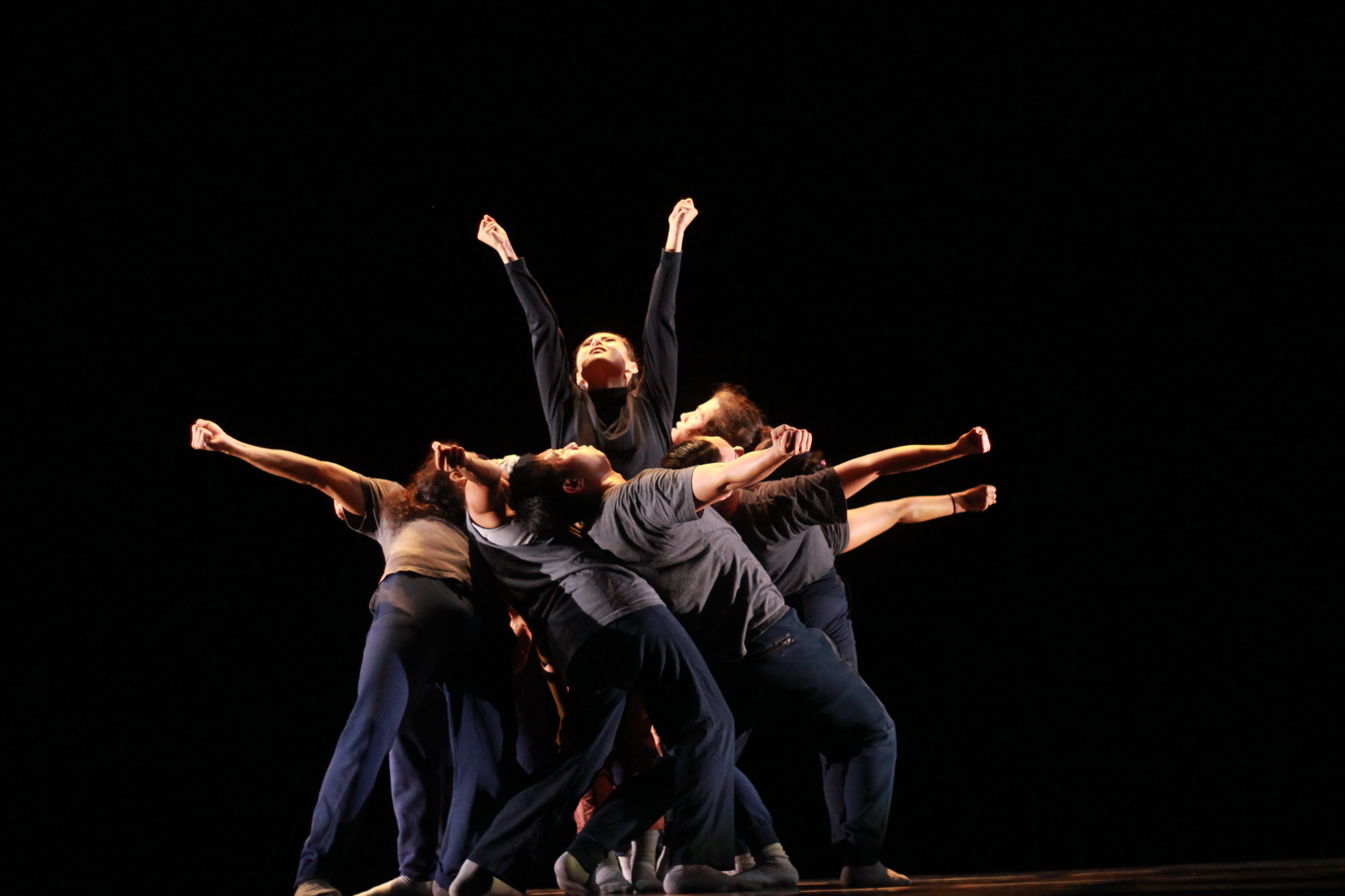 Dancers leaning on one another in a circle