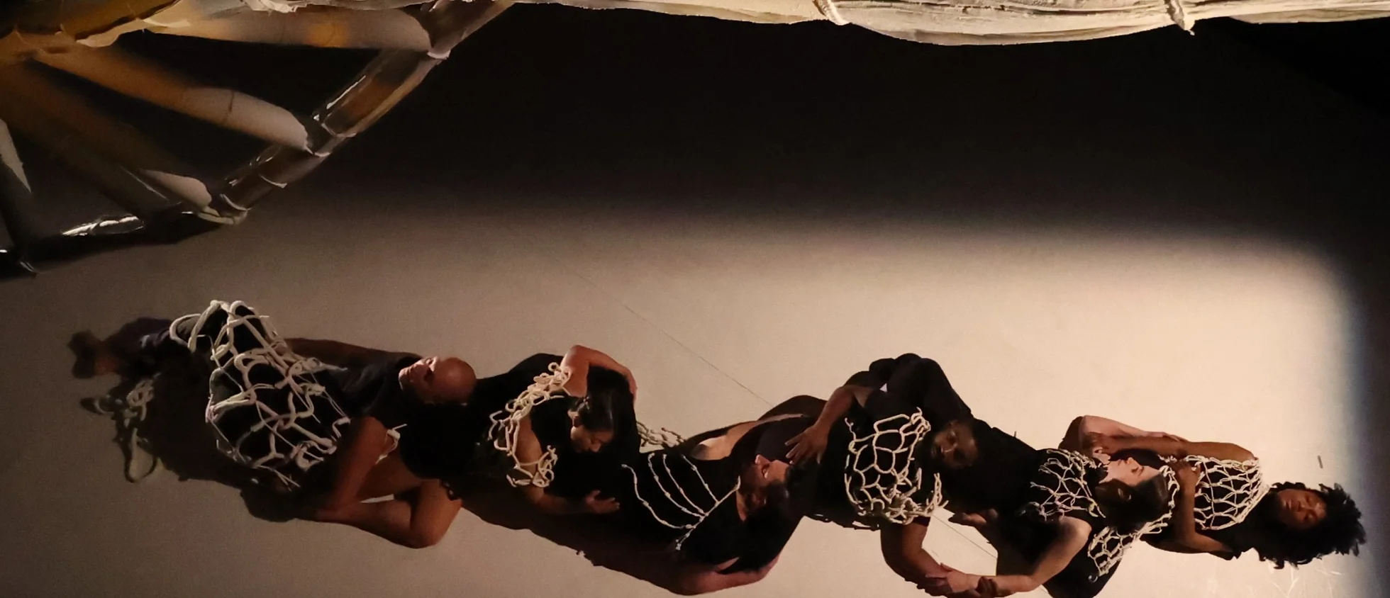 Four dancers lying on stage in costume